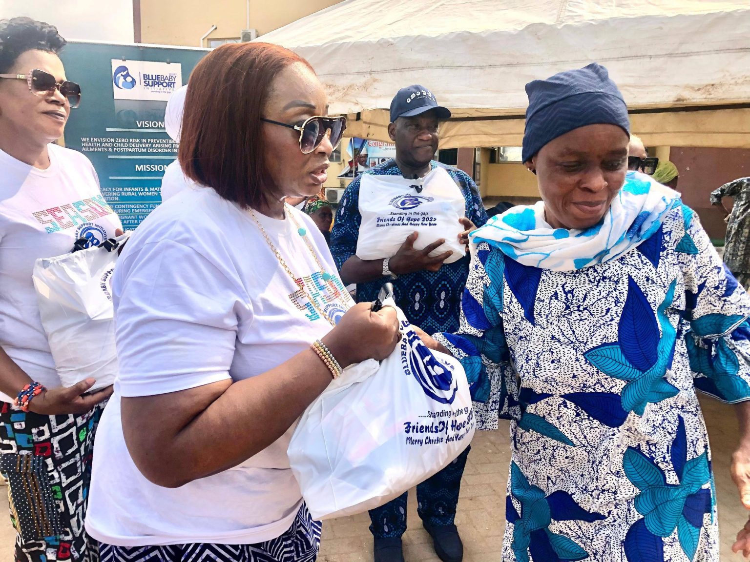 BBSI team distributing Friends of Hope relief packages to a woman in the community