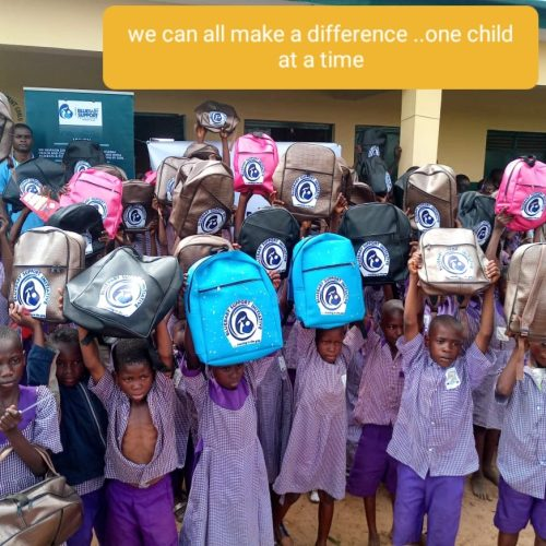 Pupils holding their new backpacks overhead in celebration