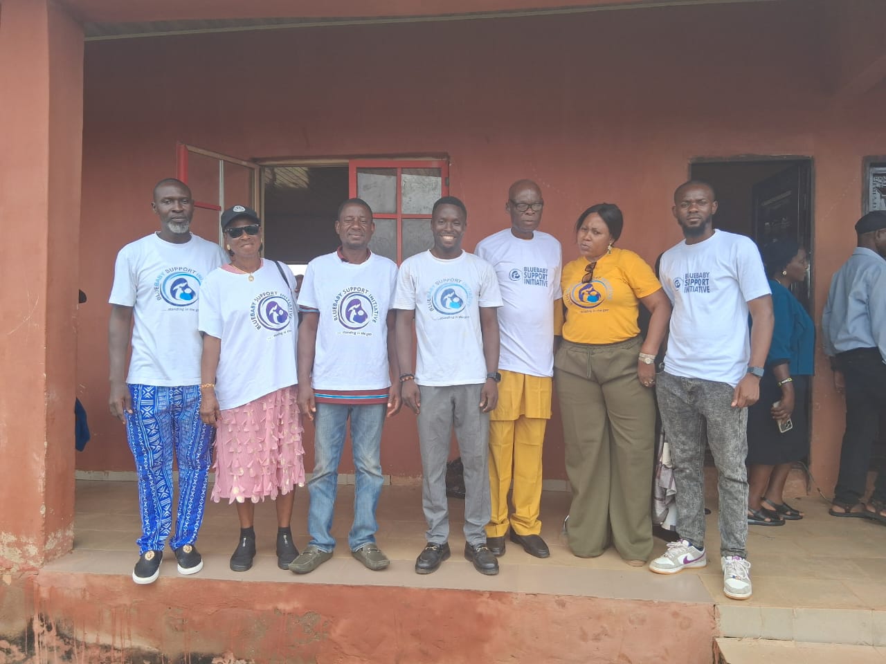 BBSI volunteers and community members posing together in BBSI branded shirts at the outreach