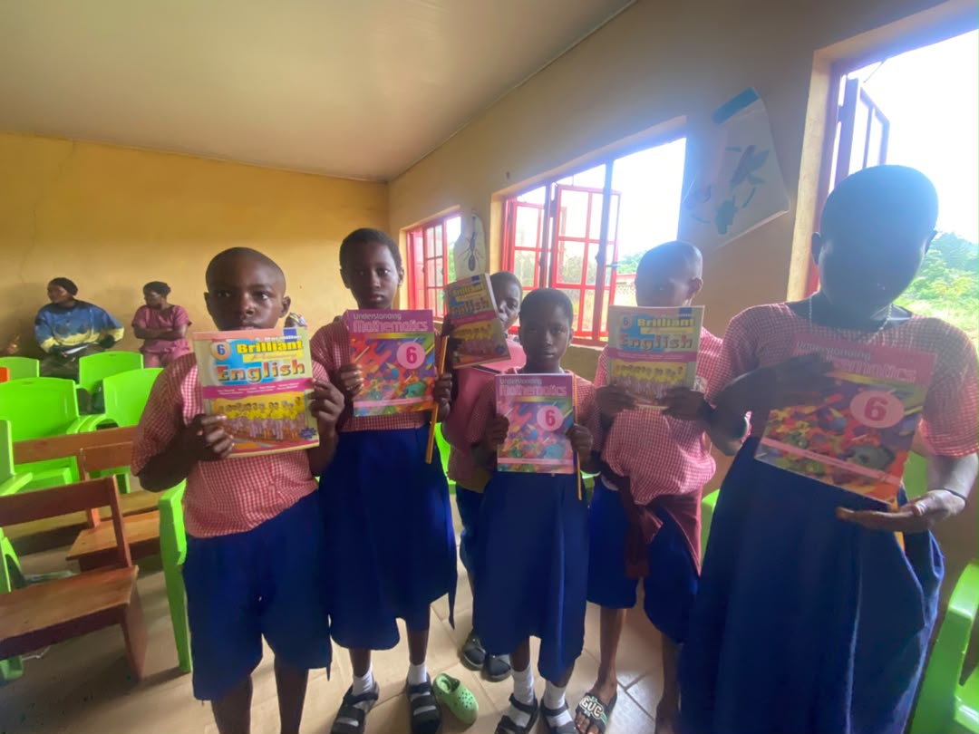 Pupils holding up their new English and Mathematics textbooks